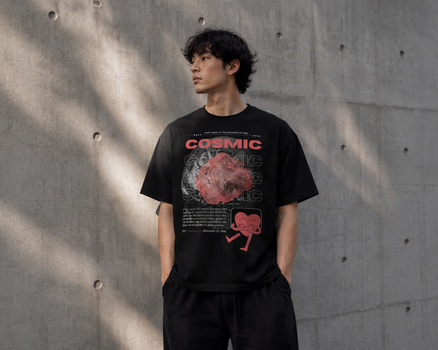 Person wearing a black t-shirt with graphic design against a concrete wall. Stylist streetwear tee, comfy formal tee, fashion tee, graphic tee