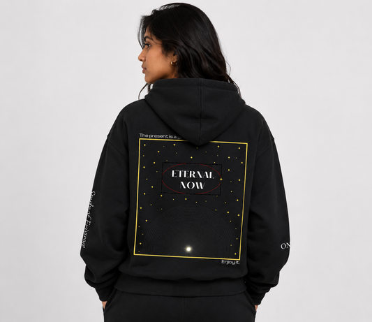 Person wearing a black hoodie with 'Eternal Now' design on the back against a white background. Stylist streetwear hoodie, comfy formal hoodie, fashion hoodie, graphic hoodie, no front pocket hoodie, large hooded hoodie, large hood hoodie, oversized hoodie