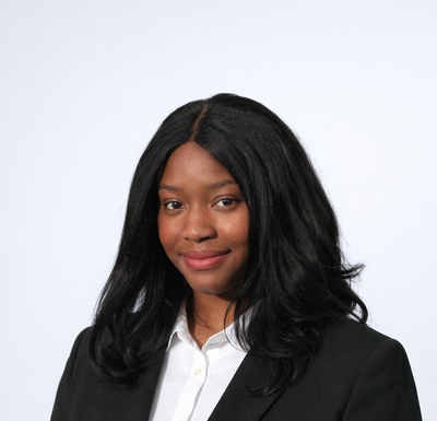 Person wearing a black blazer over a white shirt on a white background