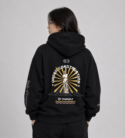 Person wearing a black hoodie with a design on the back against a gray background. Stylist streetwear hoodie, comfy formal hoodie, fashion hoodie, graphic hoodie, no front pocket hoodie, large hooded hoodie, large hood hoodie, oversized hoodie