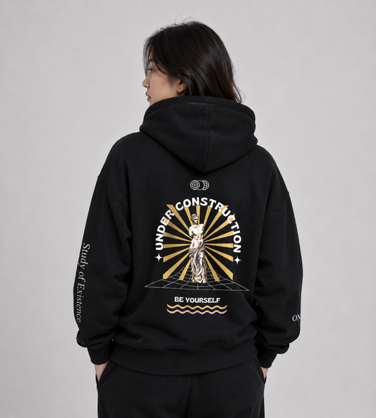 Person wearing a black hoodie with a design on the back against a gray background. Stylist streetwear hoodie, comfy formal hoodie, fashion hoodie, graphic hoodie, no front pocket hoodie, large hooded hoodie, large hood hoodie, oversized hoodie