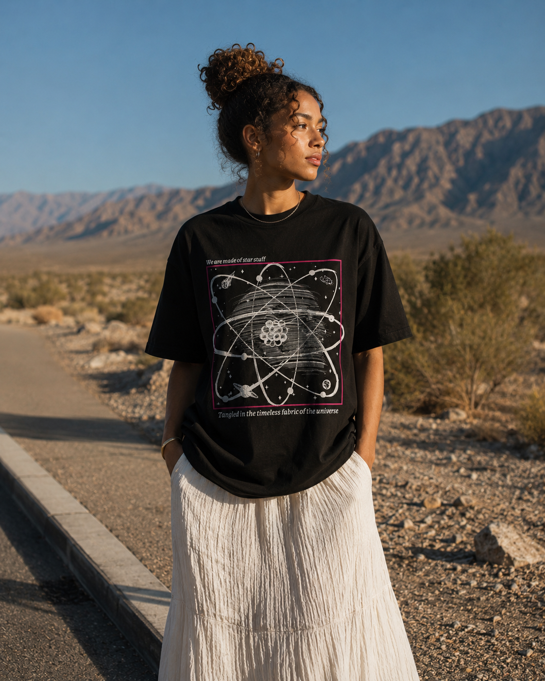Person wearing a black t-shirt with a graphic design in a desert setting.Stylist streetwear tee, comfy formal tee, fashion tee, graphic tee