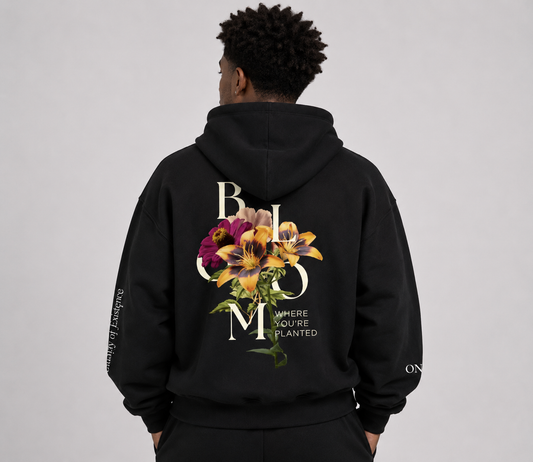 Person wearing a black hoodie with floral design and text on the back against a gray background. Stylist streetwear hoodie, comfy formal hoodie, fashion hoodie, graphic hoodie, no front pocket hoodie, large hooded hoodie, large hood hoodie, oversized hoodie