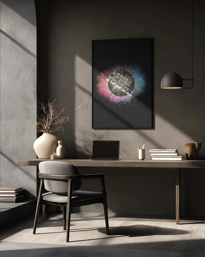 Modern office desk with a laptop, books, and decorative items against a gray wall with a framed abstract art piece.