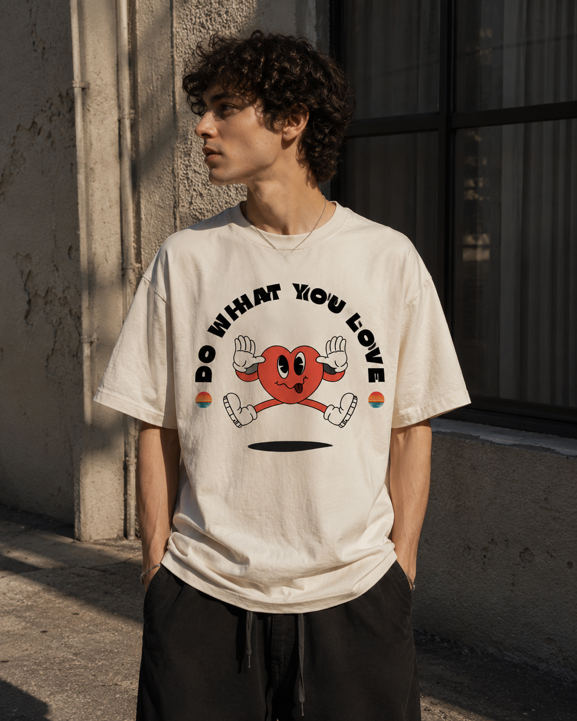 Person wearing a white t-shirt with a graphic design and text, standing against a wall. Stylist streetwear tee, comfy formal tee, fashion tee, graphic tee