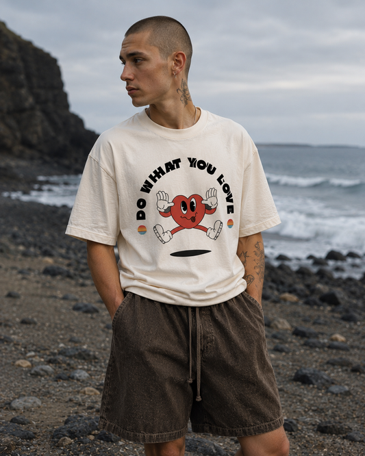 Man wearing a t-shirt with a graphic design on a rocky beach. Stylist streetwear tee, comfy formal tee, fashion tee, graphic tee