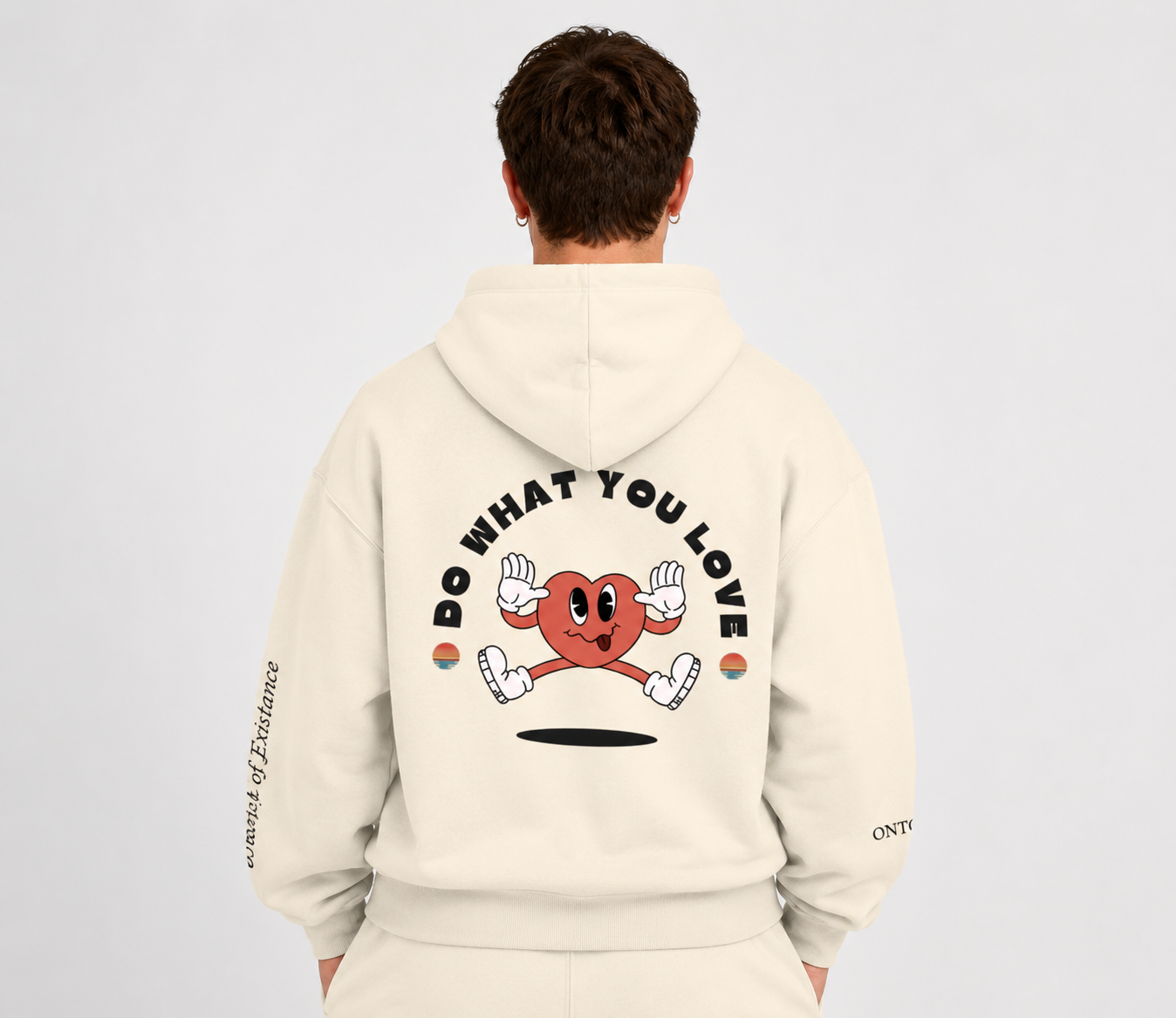 Person wearing a beige hoodie with a graphic design on the back against a light gray background. Stylist streetwear hoodie, comfy formal hoodie, fashion hoodie, graphic hoodie, no front pocket hoodie, large hooded hoodie, large hood hoodie, oversized hoodie