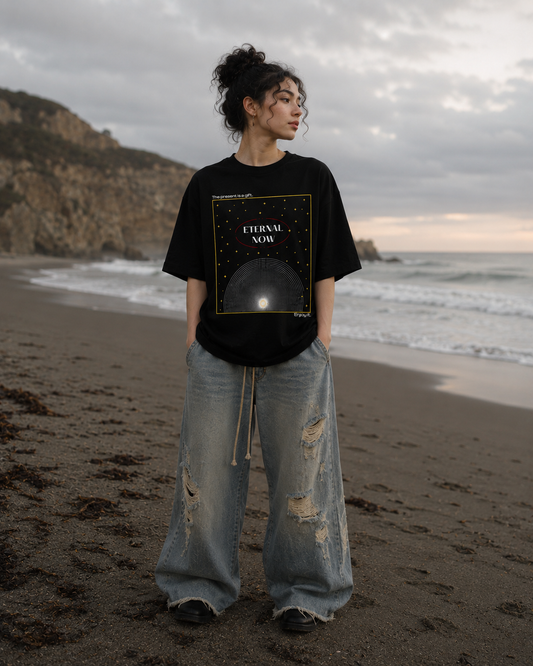 Person wearing a black t-shirt with 'Eternal Now' design on a beach. generate another picture of this tee with different gender, different race, different bottom, different background 
