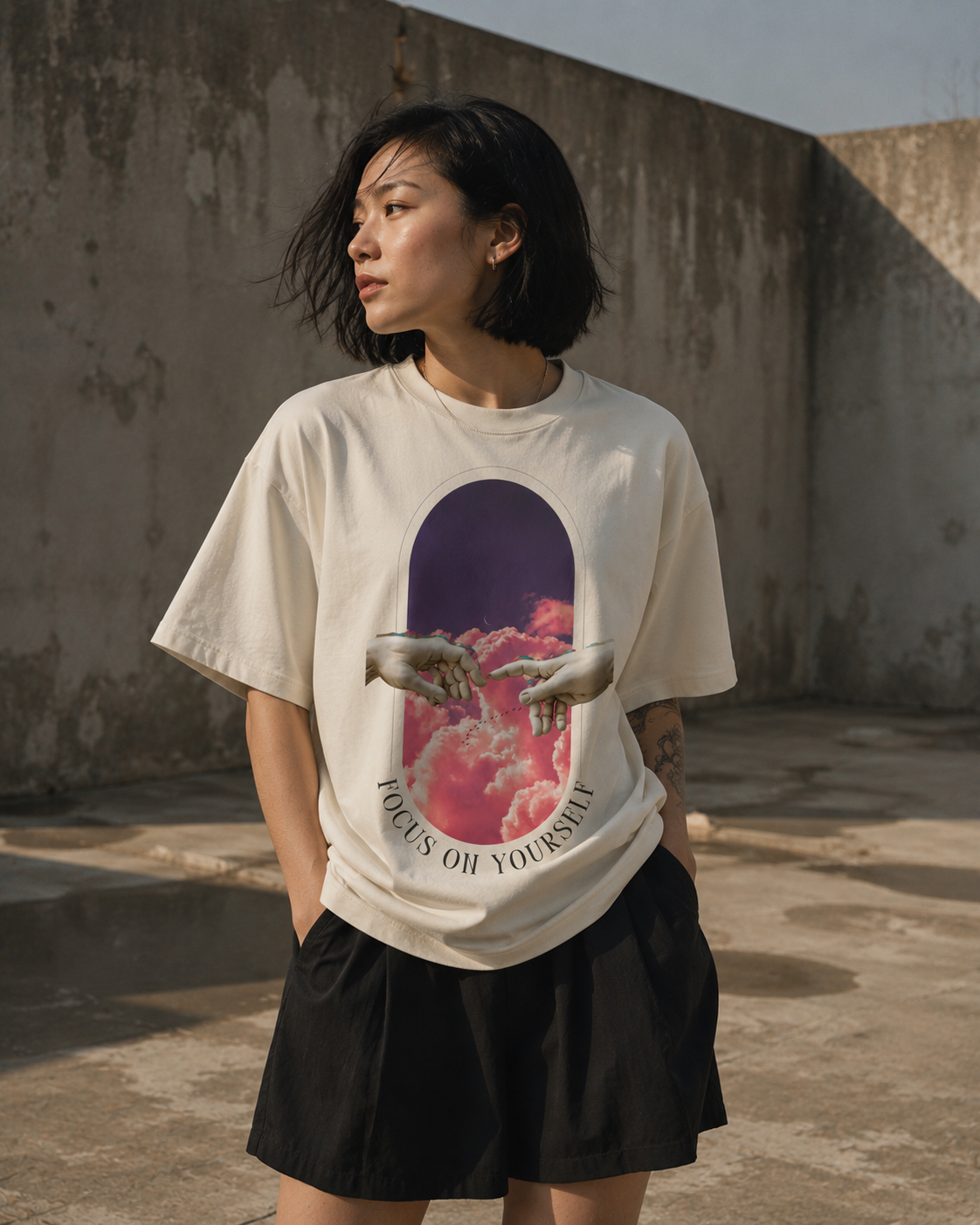 Person wearing a white t-shirt with a graphic design in an urban setting. Stylist streetwear tee, comfy formal tee, fashion tee, graphic tee