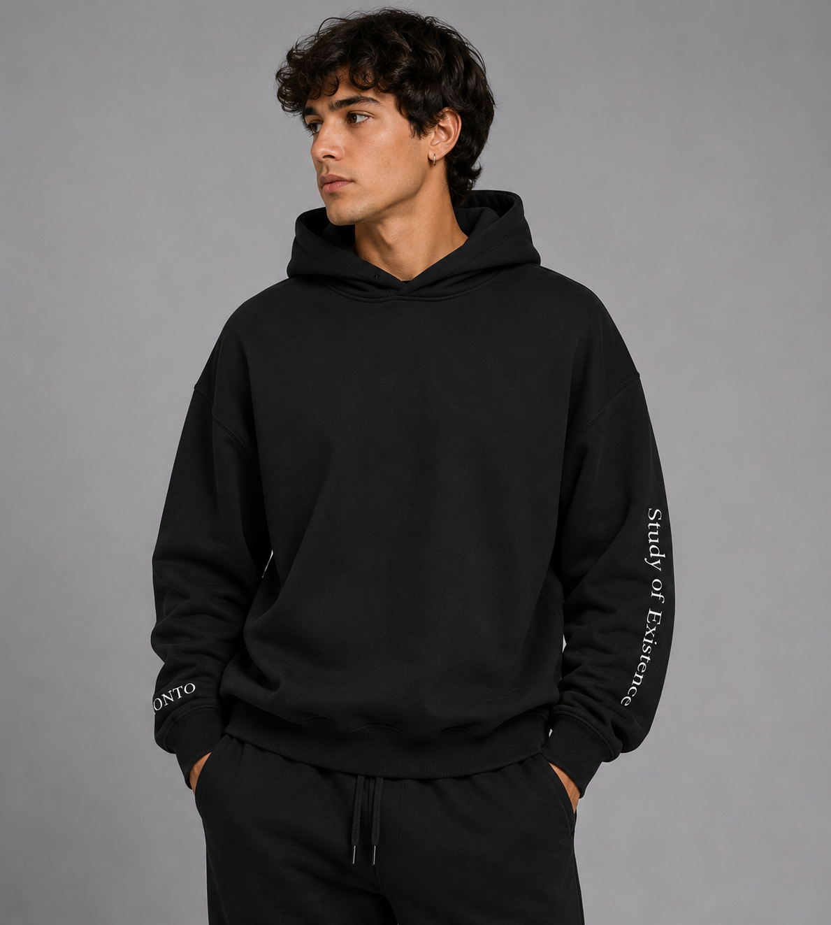 Person weating a Black hoodie with text on sleeves against a white background. Stylist streetwear hoodie, comfy formal hoodie, fashion hoodie, graphic hoodie, no front pocket hoodie, large hooded hoodie, large hood hoodie, oversized hoodie