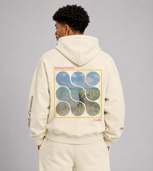 Person wearing a cream hoodie with a graphic design on the back against a gray background. Stylist streetwear hoodie, comfy formal hoodie, fashion hoodie, graphic hoodie, no front pocket hoodie, large hooded hoodie, large hood hoodie, oversized hoodie