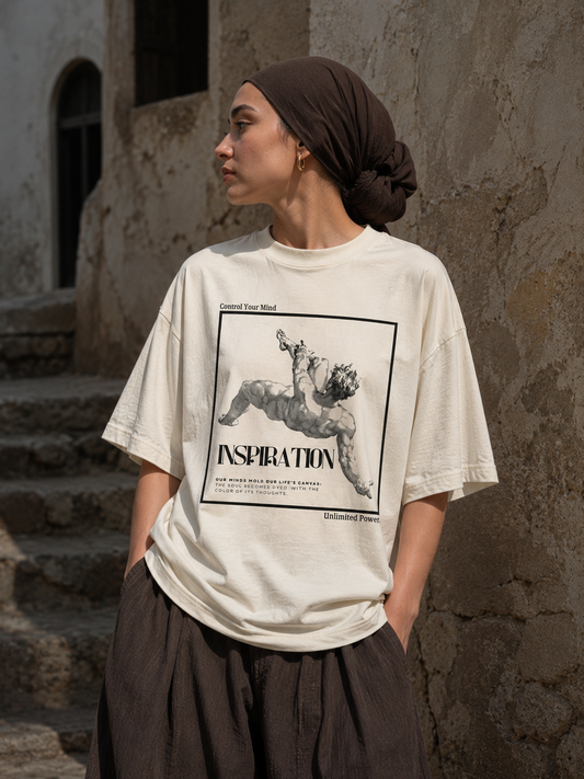 Person wearing a white t-shirt with a graphic design and text, standing against a textured wall. Stylist streetwear tee, comfy formal tee, fashion tee, graphic tee