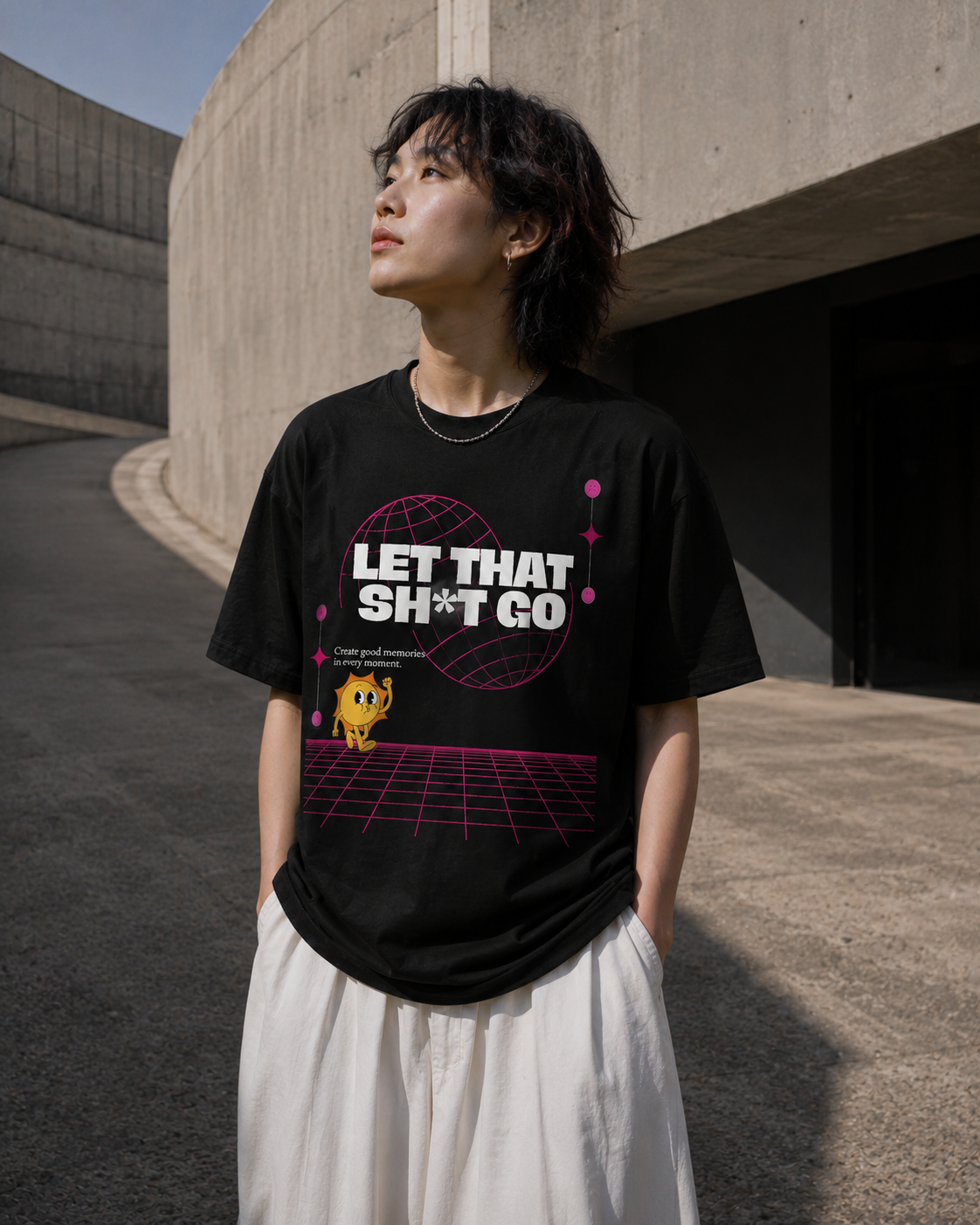 Person wearing a black t-shirt with a graphic design and text, standing in an urban setting.