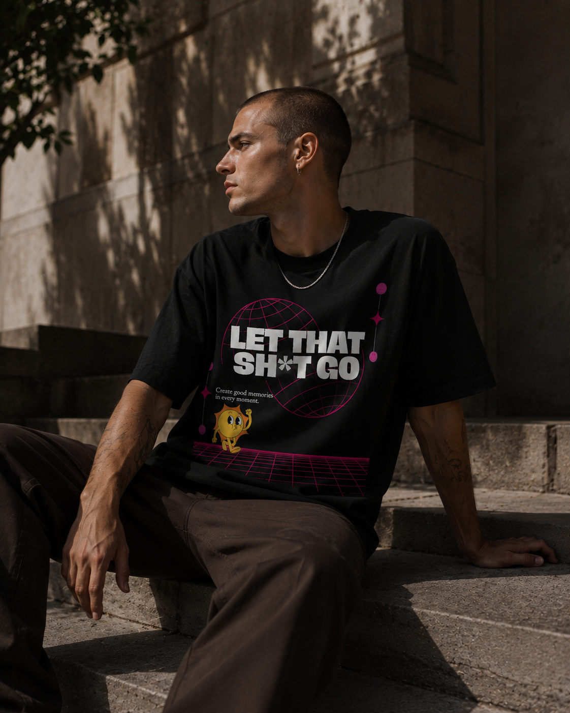 Person wearing a black t-shirt with text sitting on steps outdoors. Stylist streetwear tee, comfy formal tee, fashion tee, graphic tee