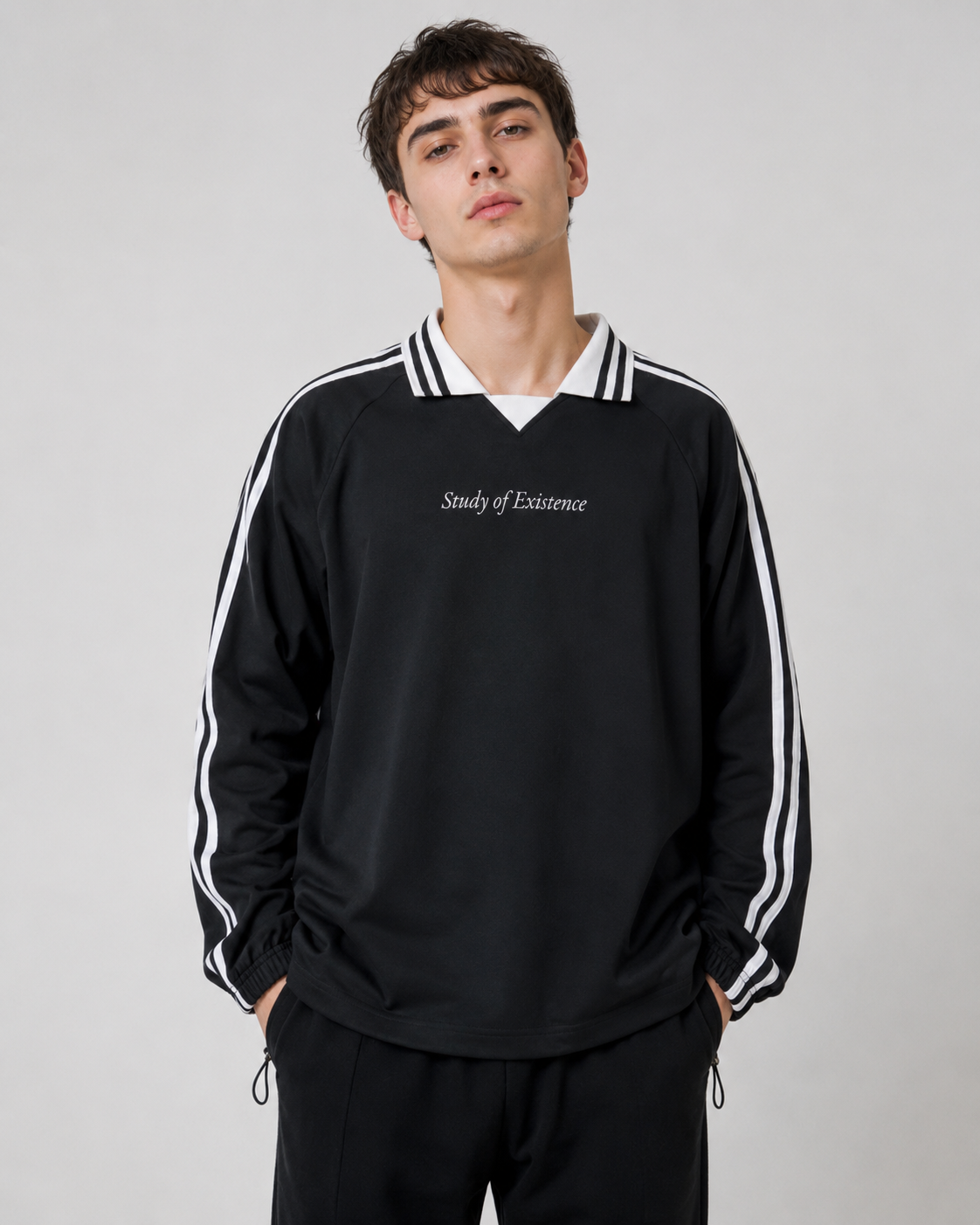 Man wearing a black tracksuit with white stripes and 'Study of Existence' text on a gray background. Stylist streetwear collar Sweatshirt, comfy formal collar Sweatshirt, fashion collar Sweatshirt, graphic collar Sweatshirt