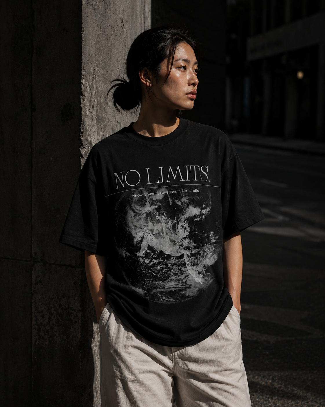 Person wearing a black t-shirt with 'NO LIMITS' text and graphic design, standing against a dark background. Stylist streetwear tee, comfy formal tee, fashion tee, graphic tee