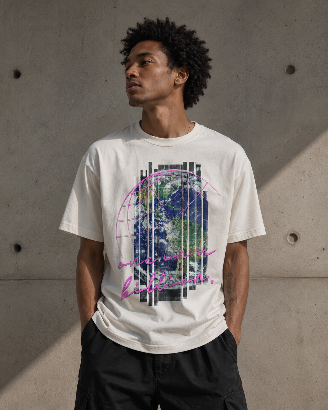 Person wearing a off-white t-shirt with a graphic design and text, standing against a concrete wall. Stylist streetwear tee, comfy formal tee, fashion tee, graphic tee