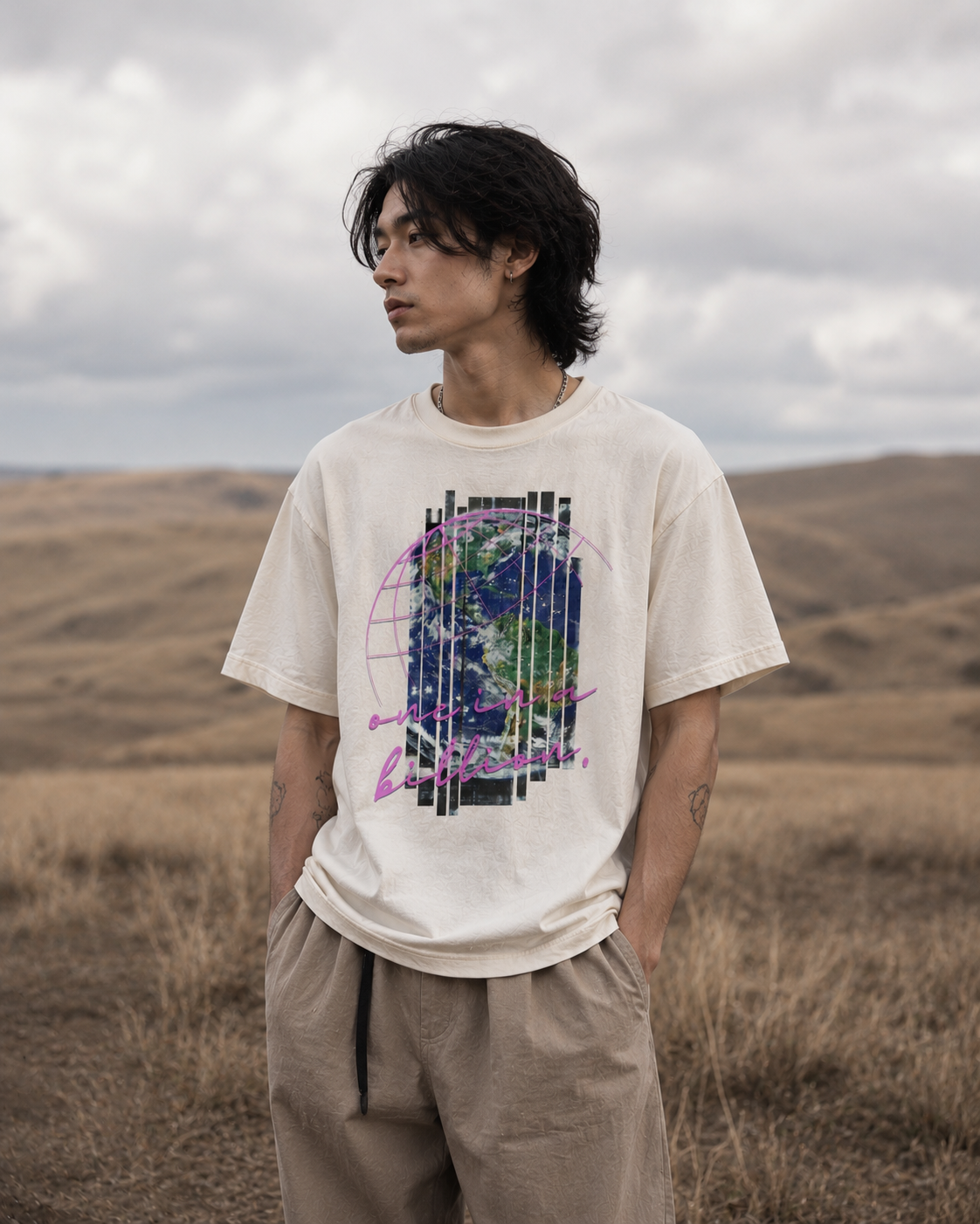 Person wearing a white t-shirt with a graphic design in a desert landscape. Stylist streetwear tee, comfy formal tee, fashion tee, graphic tee