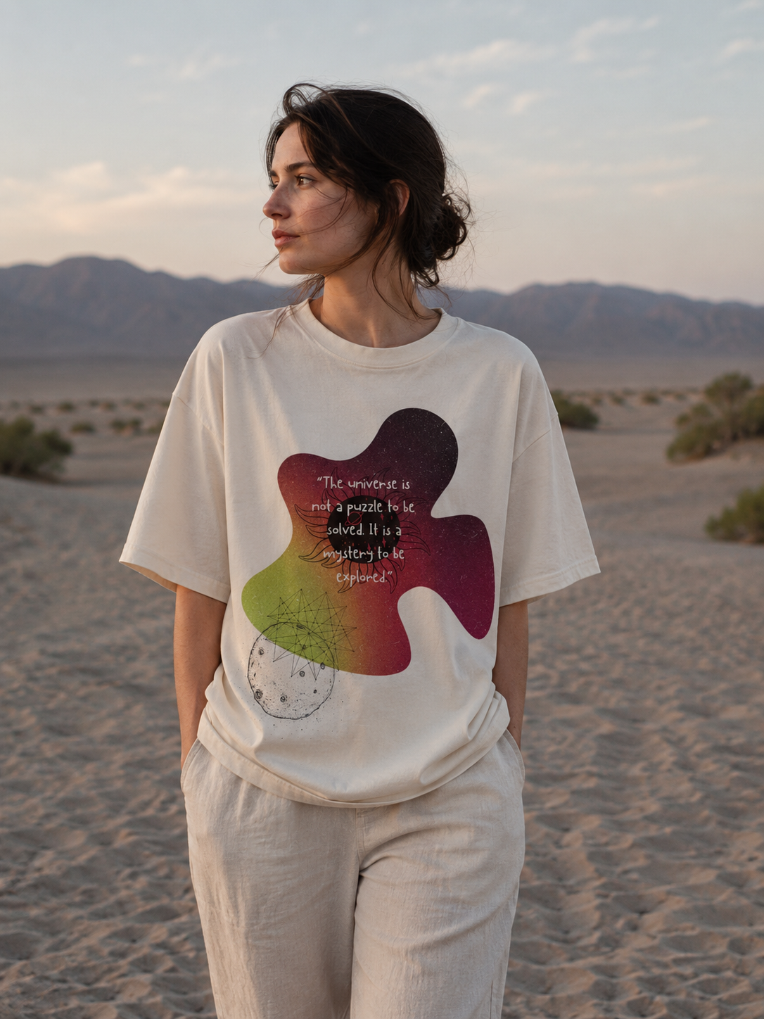 Person wearing a white t-shirt with a colorful abstract design in a desert setting Stylist streetwear tee, comfy formal tee, fashion tee, graphic tee