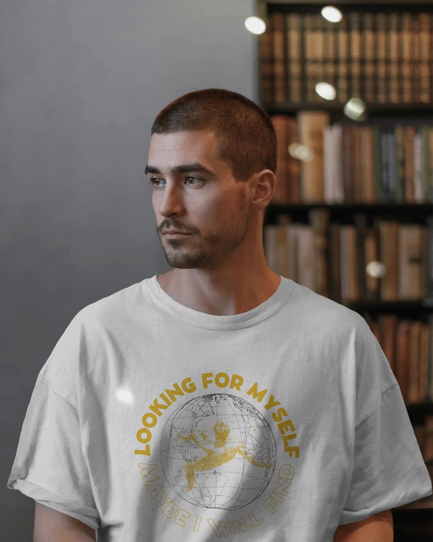 Man wearing a white t-shirt with a graphic design in a library setting