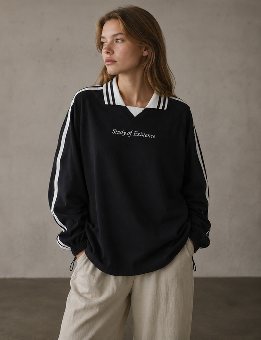 Person wearing a black sweatshirt with white stripes and text, standing against a plain background. Stylist streetwear collar Sweatshirt, comfy formal collar Sweatshirt, fashion collar Sweatshirt, graphic collar Sweatshirt