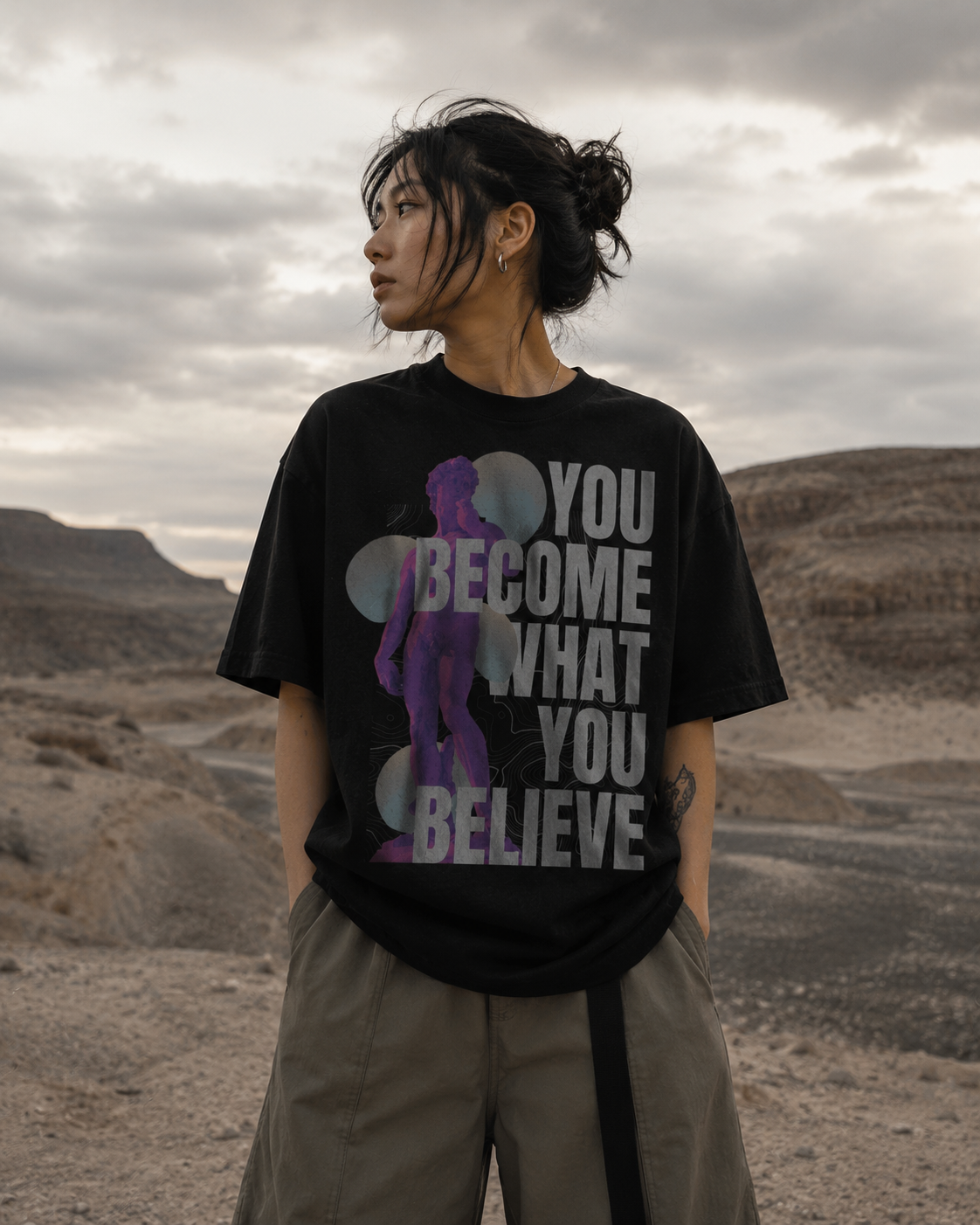 Person wearing a black t-shirt with motivational quote in a desert landscape. Stylist streetwear tee, comfy formal tee, fashion tee, graphic tee