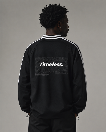 Person wearing a black jacket with 'Timeless.' text on the back against a gray background. Stylist streetwear collar Sweatshirt, comfy formal collar Sweatshirt, fashion collar Sweatshirt, graphic collar Sweatshirt