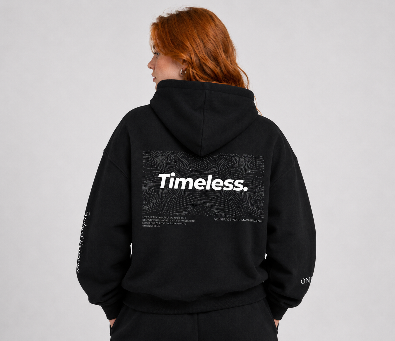 Person wearing a black hoodie with 'Timeless.' text on the back against a gray background. Stylist streetwear hoodie, comfy formal hoodie, fashion hoodie, graphic hoodie, no front pocket hoodie, large hooded hoodie, large hood hoodie, oversized hoodie