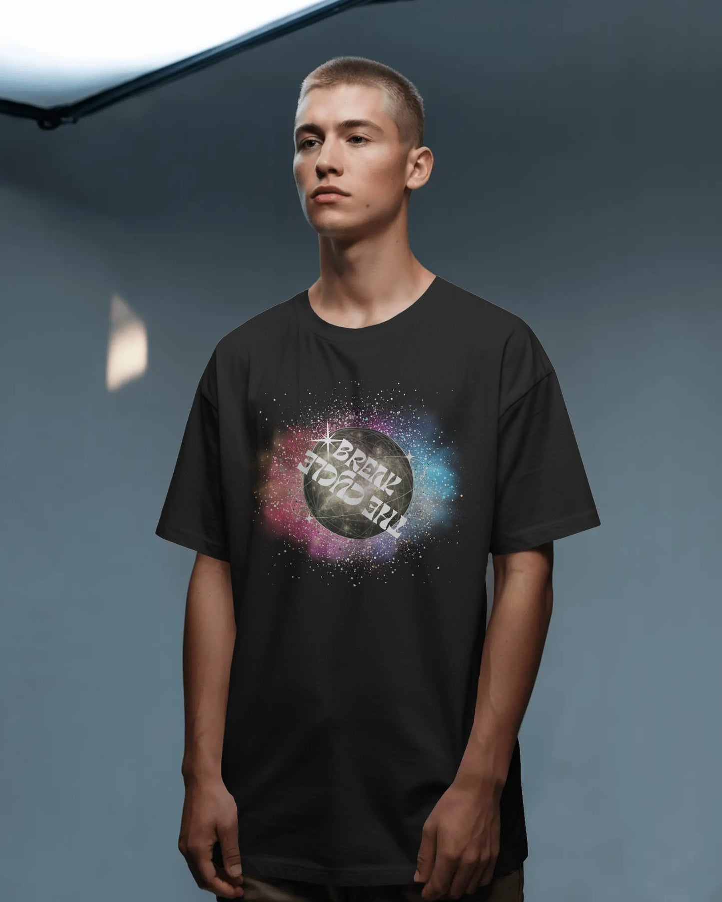 Person wearing a black t-shirt with a colorful graphic design on a gray background