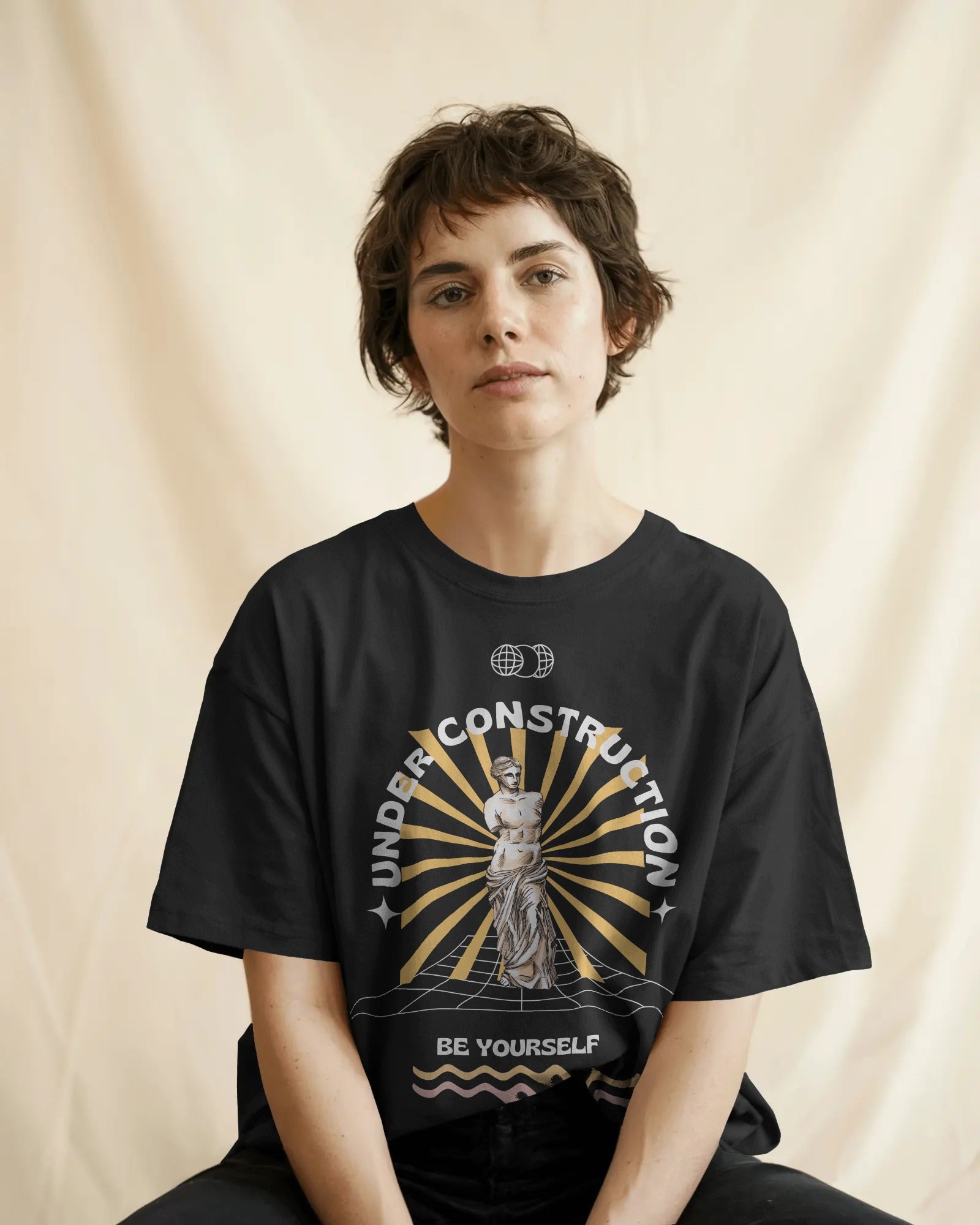 Person wearing a black t-shirt with a graphic design and text on a beige background