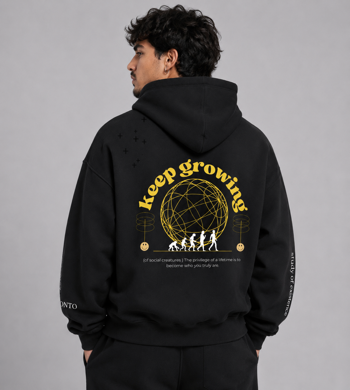 Person wearing a black hoodie with 'keep growing' text and graphic on the back, standing against a gray background. Stylist streetwear hoodie, comfy formal hoodie, fashion hoodie, graphic hoodie, no front pocket hoodie, large hooded hoodie, large hood hoodie, oversized hoodie