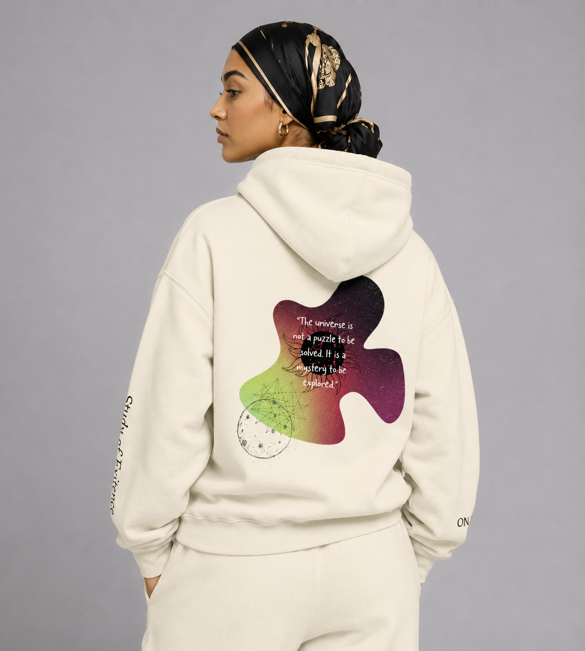 Person wearing a cream-colored hoodie with a colorful puzzle piece design on the back, standing against a gray background. Stylist streetwear hoodie, comfy formal hoodie, fashion hoodie, graphic hoodie, no front pocket hoodie, large hooded hoodie, large hood hoodie, oversized hoodie