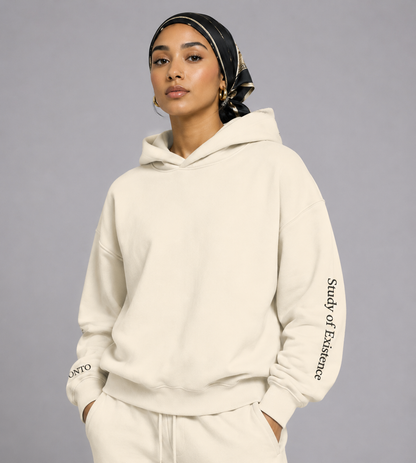 Person wearing a beige hoodie with text on the sleeve against a gray background. Stylist streetwear hoodie, comfy formal hoodie, fashion hoodie, graphic hoodie, no front pocket hoodie, large hooded hoodie, large hood hoodie, oversized hoodie