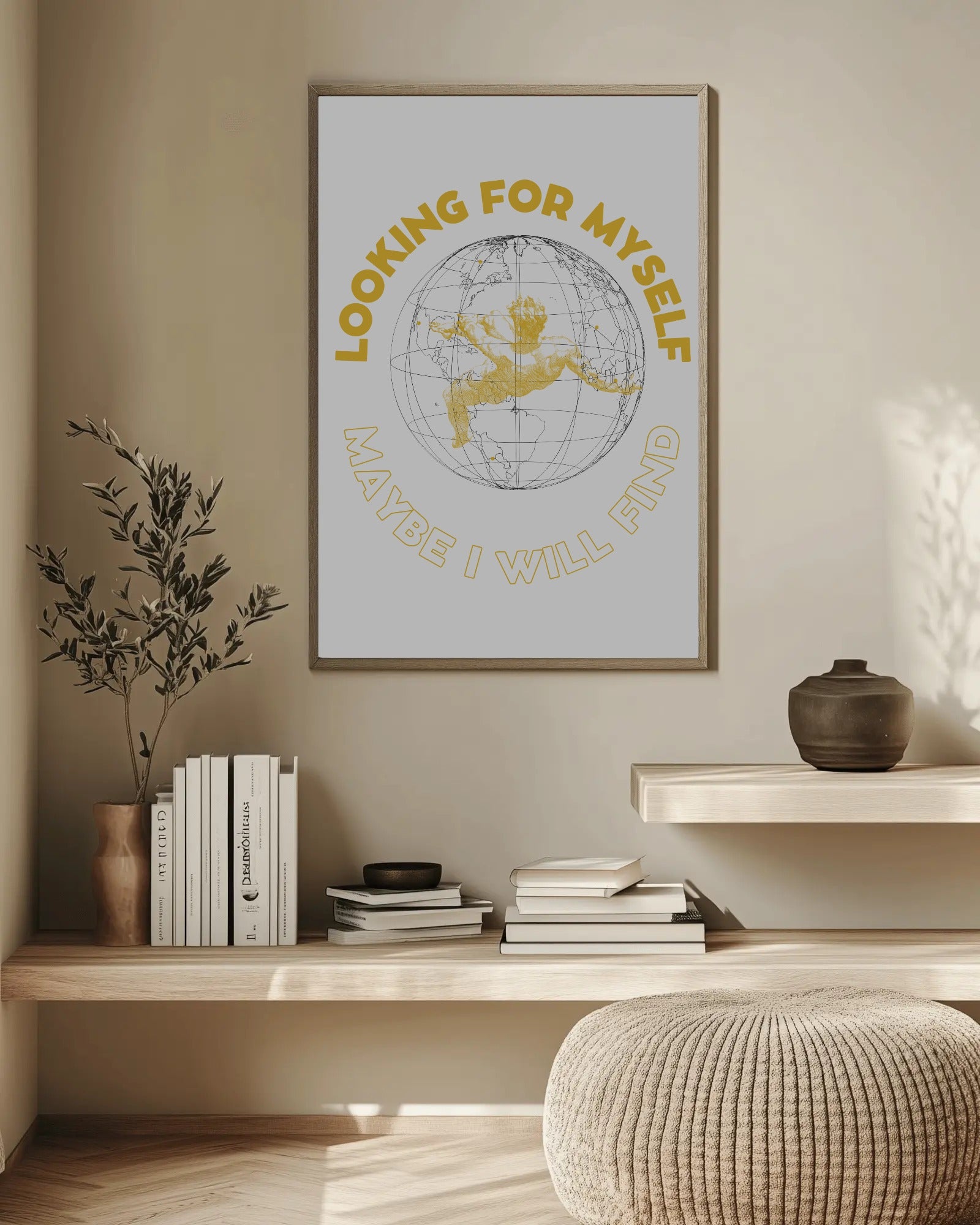 Framed artwork on a wall above a wooden shelf with books and decor items.