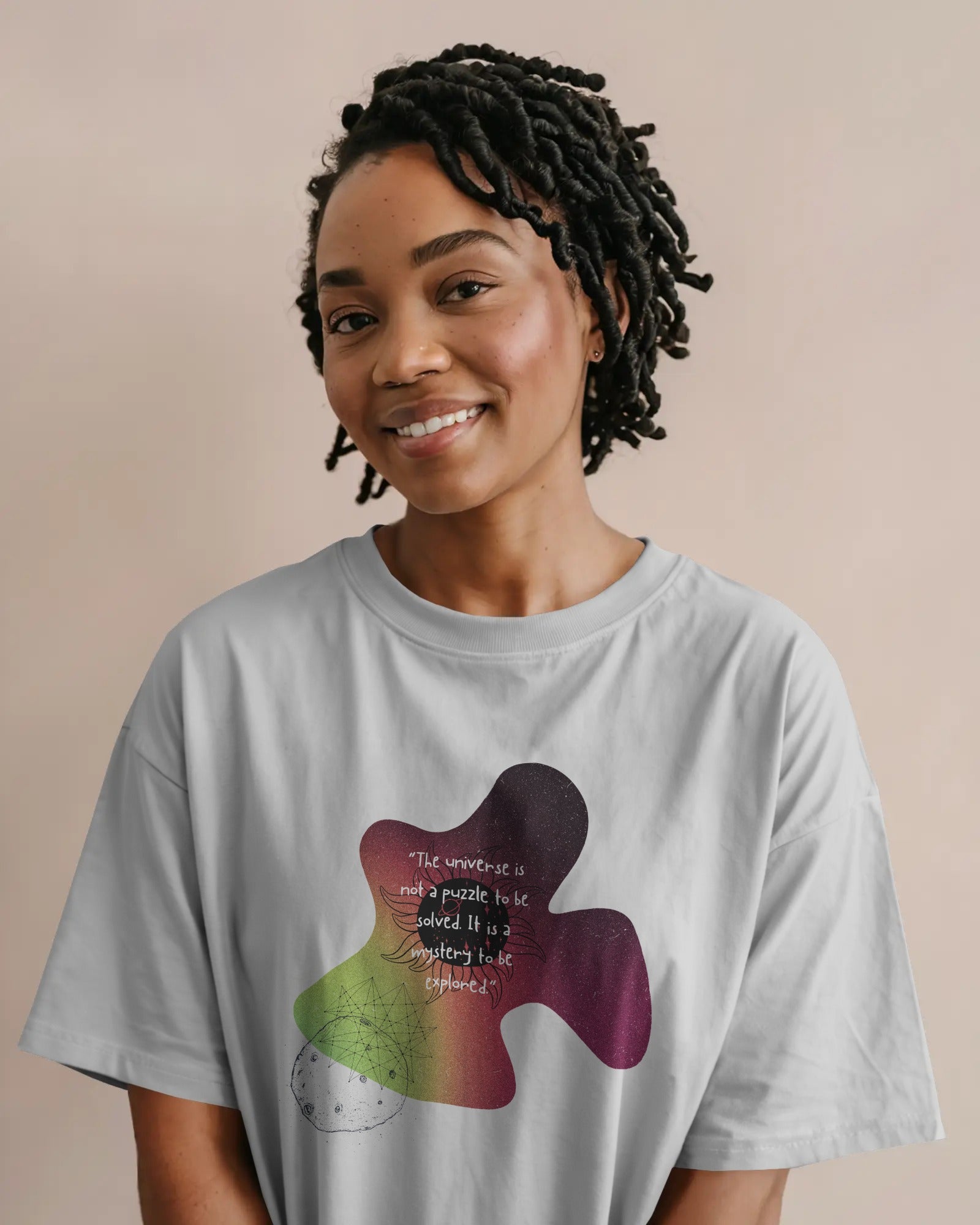 Person wearing a light gray t-shirt with a colorful abstract design and text.