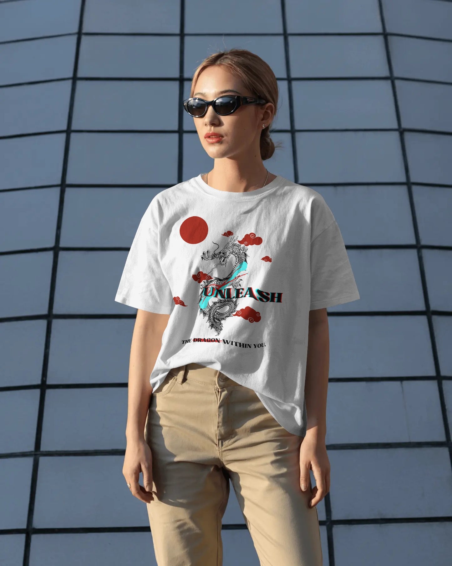 Person wearing a white t-shirt with graphic design and text, standing against a geometric wall.
